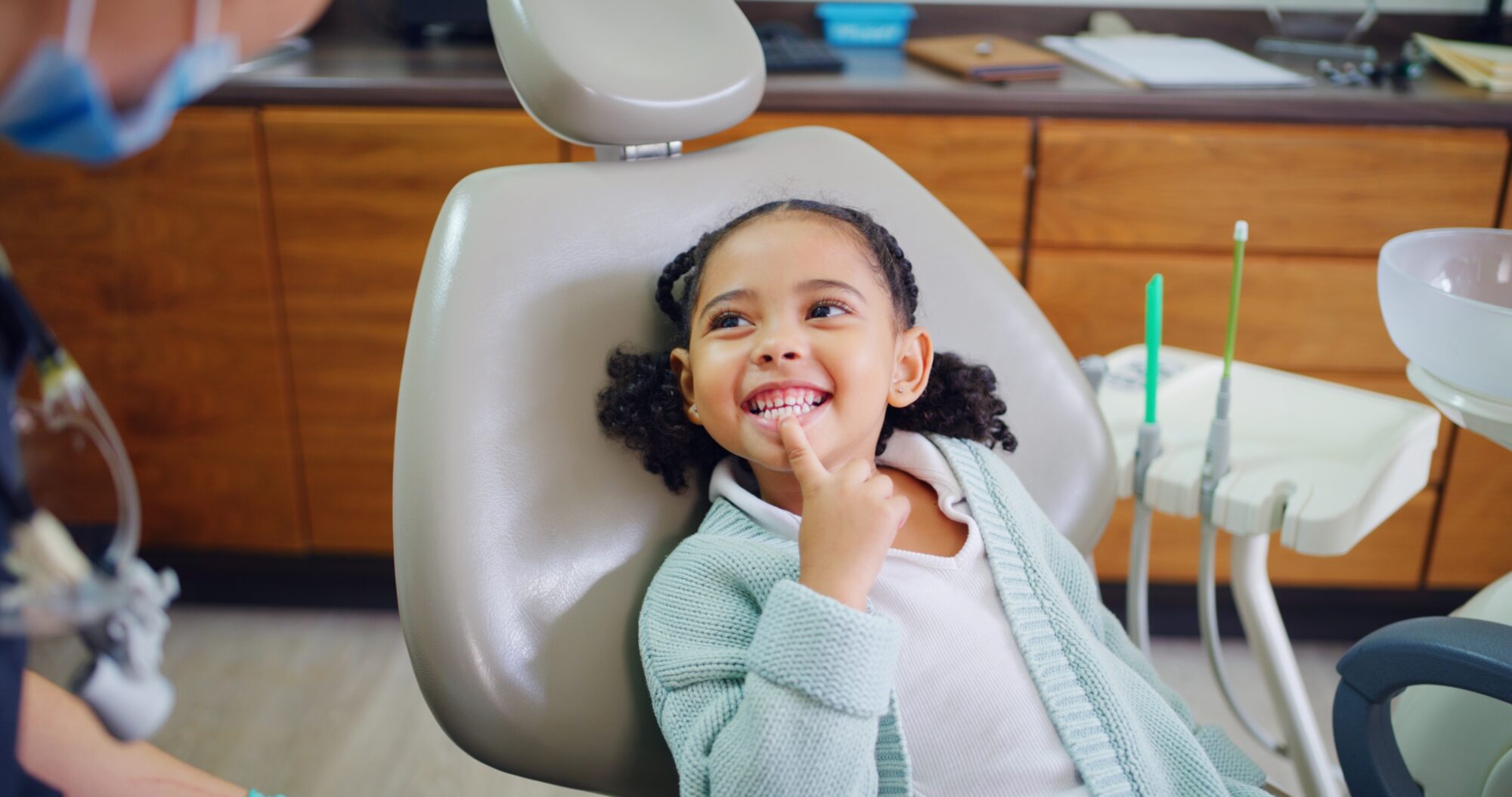 Young girl showing her teeth to dentist.